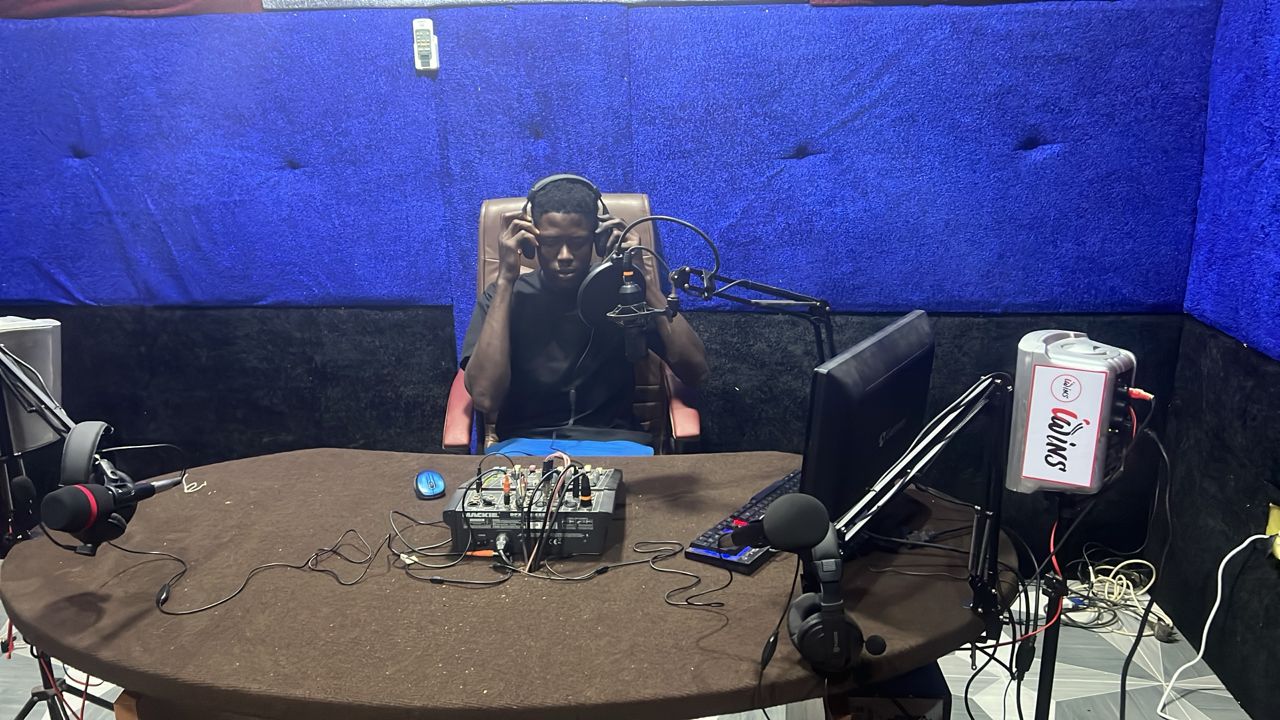 Student in headphones at the Iwins Radio broadcast table